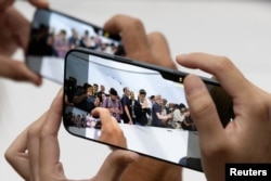 Attendees try out the new iPhone 16 as Apple holds an event at the Steve Jobs Theater on its campus in Cupertino, California, on September 9, 2024.